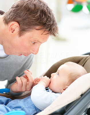 Young father making a funny face at his baby