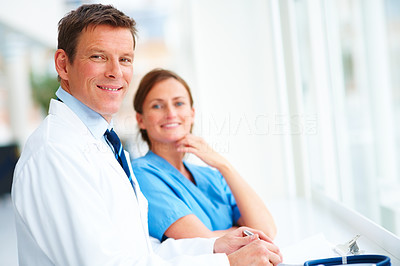 Happy confident doctor and a nurse working together