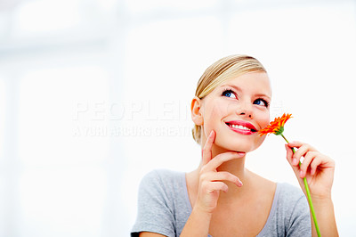 Portrait of charming young female with a flower and thinking about love