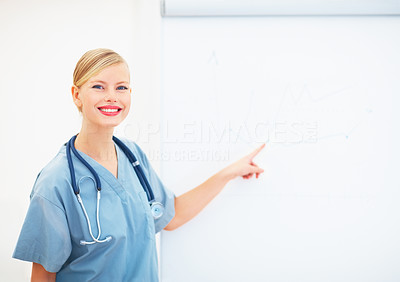 Portrait of young lady surgeon pointing at blank board