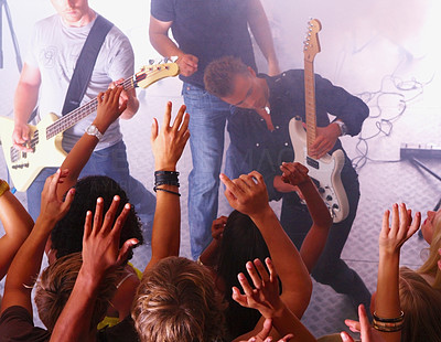 Men playing guitar and people raising hands at disco