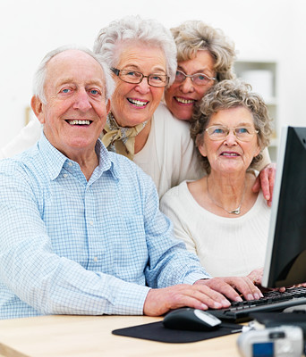 Group of mature people together on computer