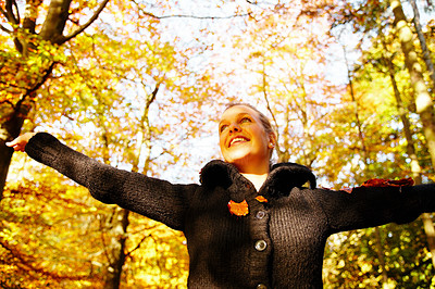 Portrait of smiling young girl spreading her arms out in the forest