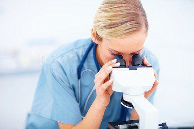Young doctor looking into a microscope in laboratory