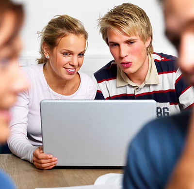 Two young college students using laptop
