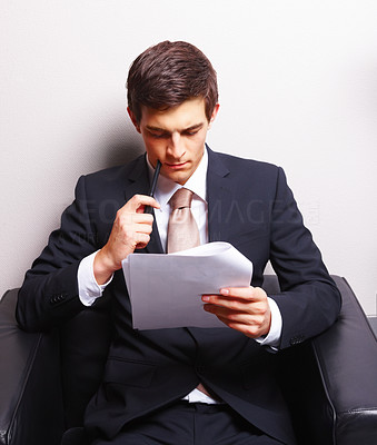 Young business man sitting and reading paper