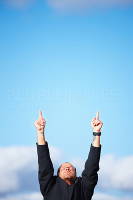 Ambitious businessman pointing upwards to copyspace