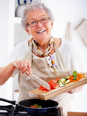 Closeup of an old woman smiling and cooking food