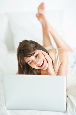Happy young woman using a laptop at home