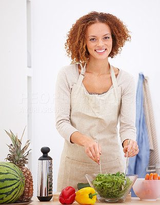 Happy young lady preparing food in a kitchen