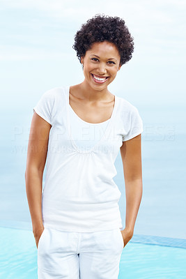Pretty young woman with hands in pockets standing outdoors