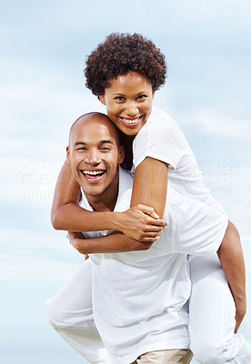 Joyful young man carrying girlfriend on his back
