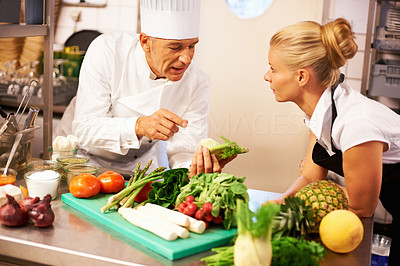 Chef giving cooking lessons to trainee