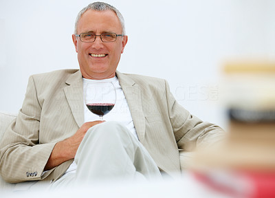 Mature business man relaxing at home with a wine glass