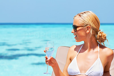Sexy young lady relaxing at the seaside with a drink