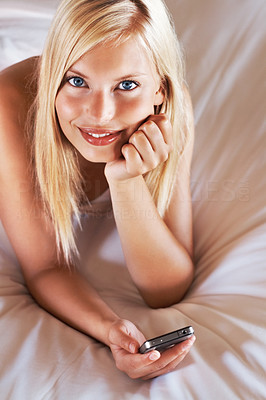 Beautiful woman on bed with a mobile phone