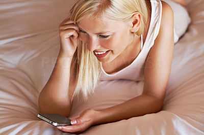 Lovely woman reading a text message on bed