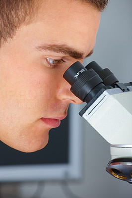 Closeup of a researcher looking through telescope at lab