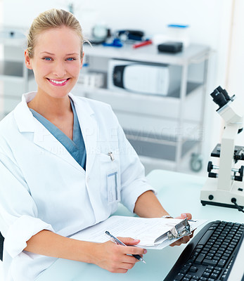 Happy female researcher by microscope smiling