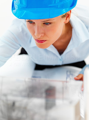 Closeup of a female architect working on blue prints