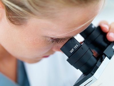 Detail view of a female researcher using microscope