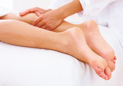 Closeup of beautiful legs receiving massage on white