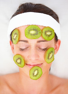 Closeup of kiwi slices on a young girl\'s face