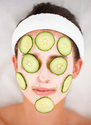 Closeup of cucumber slices and facial mask on a young girl\'s face