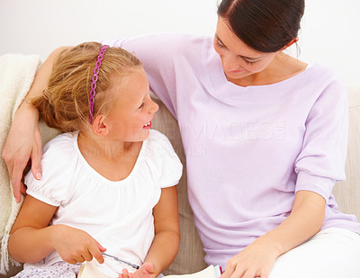 Portrait of a smiling young mother with her daughter reading a book