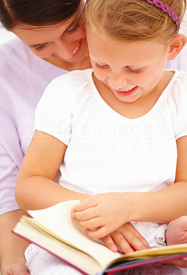 Portrait of a happy young mother with her daughter reading a book