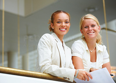 Two beautiful happy business women standing side by side