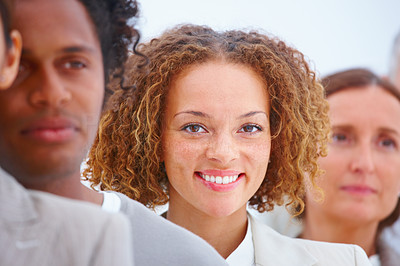 Closeup portrait of a smiling business woman with executives against white