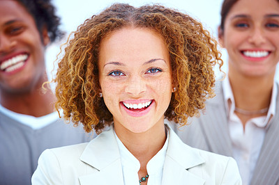 Portrait of a smiling business woman standing with executives against white background