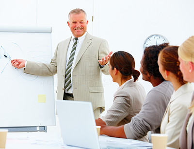 Mature happy speaker at a business meeting giving a presentation