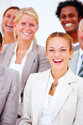 Closeup portrait of a smiling business woman standing with executives against white