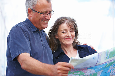 Happy old couple holding map