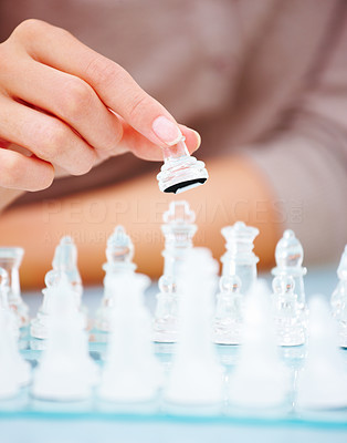 womans hand holding chess piece.