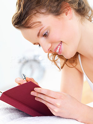 Cheerful woman writing diary