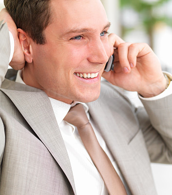 Young smiling business man using cell phone with hand behind head