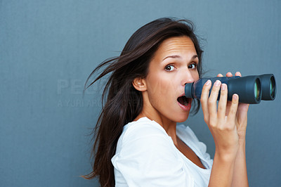 Surprised woman holding binoculars