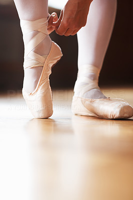 Female ballet dancer putting on performance shoes