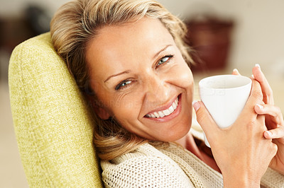 Closeup shot of a cheerful woman with a tea cup smiling