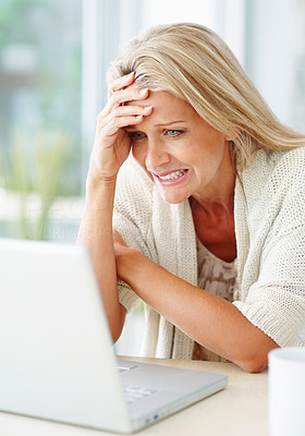 Beautiful business woman reading bad news on laptop