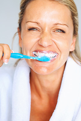 Detail view of a mature woman brushing her teeth