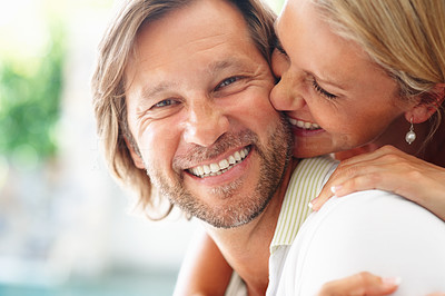 Mature woman kissing a happy guy tenderly with a smile