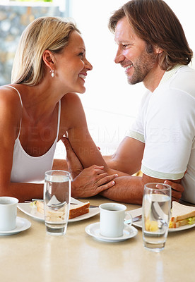 Loving mature couple looking at each other during breakfast