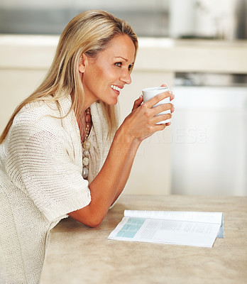 Side view of woman smiling over a thought while drinking tea