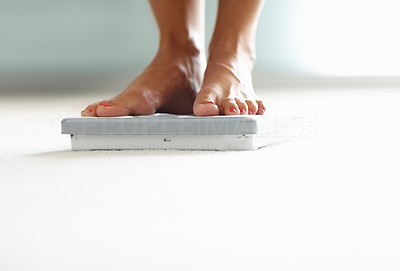 Low section of a woman\'s feet on weighing scale