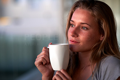 Thoughtful young girl having a hot cup of coffee