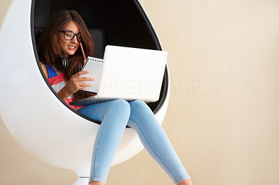Cute girl using laptop and taking notes